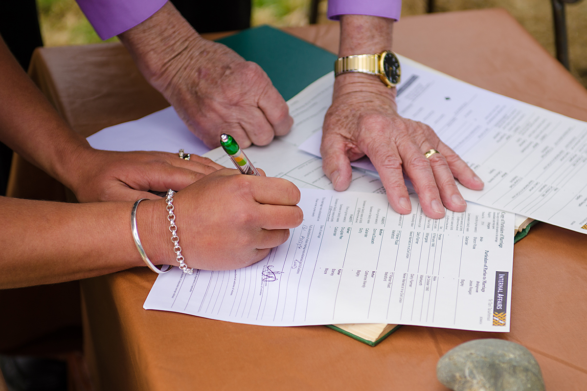 brid and groom signing marrige certificate