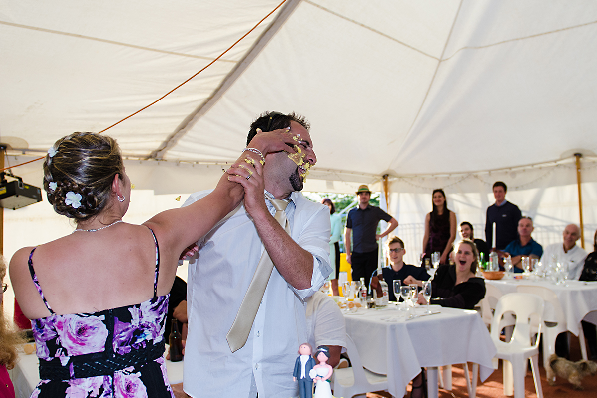 bride and groom cutting and eating wedding cake